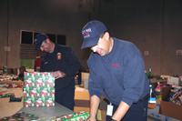 Wayne Pietzsch (left) and Steve Noack of the Fire Department put the finishing touches on their Blue Santa presents.
