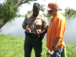 Park Ranger Reshard Durdley uses an iPad to help a visitor to Old Settlers Park
