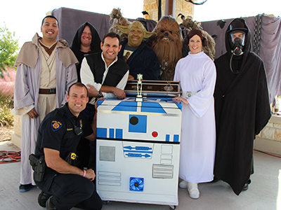 The Rock Solid Safety Team won  first place in the costume contest: (from left) Josh Bonney, Pete Wagner, Ricky Virgne, Mike Heard, Bill Clifton, Jody Virgne, Jeff Foster. Kneeling: Joseph Claypool. Center: R2D2.